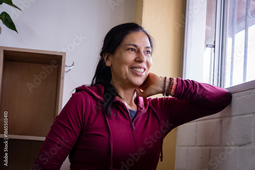 Woman smiling thoughtfully looking out window