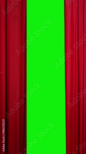 Vertical elegant red curtain opening to reveal green screen background with luxurious fabric motion, creating a cinematic stage effect perfect for transitions, video intros, theater and performance.