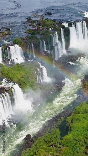 Iguazu Falls In Foz Do Iguacu Parana Brazil. Powerful Waterfall Cascading Over Rocky Cliff Into Mist. Nature Sky Clouds Mountain Canyon. Landscaping Mountain Powerful Flow. Foz do Iguacu Parana.