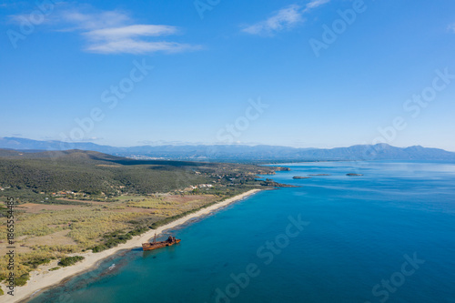 Wallpaper Mural Aerial view of the Dimitrios shipwreck resting on a long sandy beach with turquoise sea and lush hills near Gythio, Greece. Bright sunlight and a vast blue sky create a peaceful, expansive coastal Torontodigital.ca