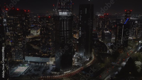 Establishing aerial view of Manchester at night. Illuminated skyline of city in the north of England, United Kingdom
