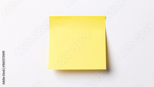A single, blank yellow sticky note sits centered on a clean white background, casting a soft shadow that adds depth to the minimalist composition.