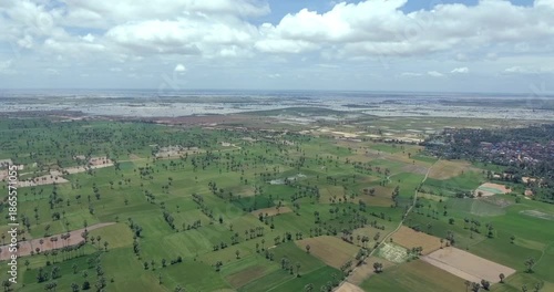 Aerial view of Cambodian countryside with rice fields and palm trees near flooded plains