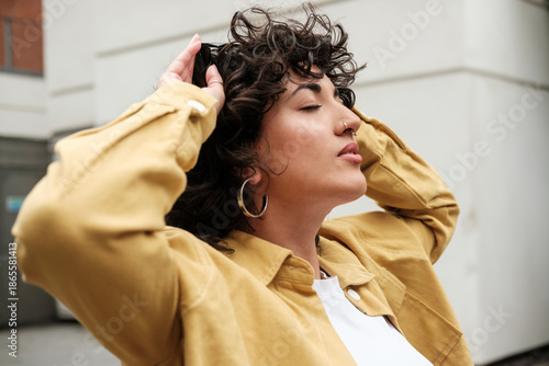 Canvas Print Young stylish woman enjoying moment with eyes closed outdoors