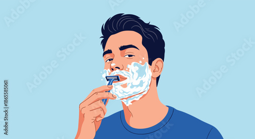 Young man with dark hair applies white shaving foam and uses a blue razor to shave his face against a clean light blue background.