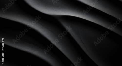 Dark undulating waves of textured black with subtle light reflections abstract