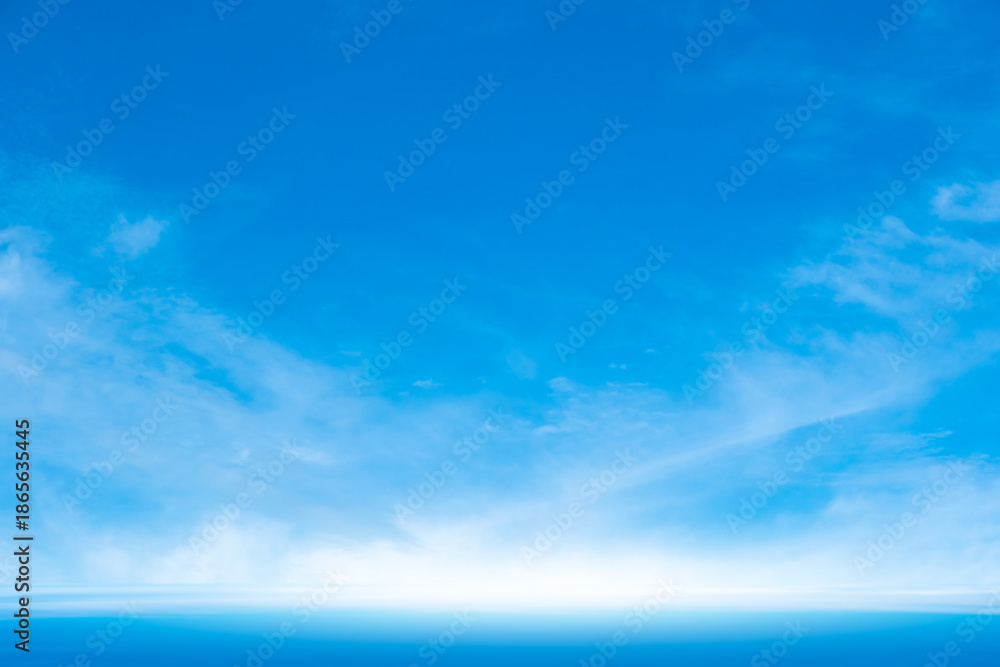 Fototapeta premium A bright, clear blue sky meets a glowing white horizon, suggesting a serene, open, and with sunlight of beautiful cloudy sky. landscape or abstract background. 