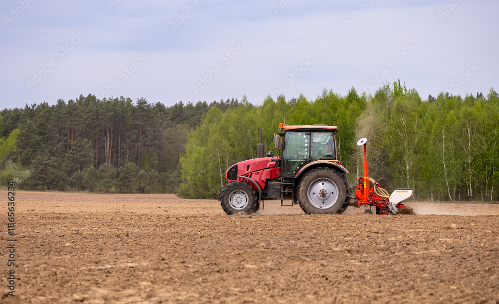 Obraz premium Tractor drilling seeding crops at farm field. Agricultural activity. Tractor spraying pesticides at soy bean fields.