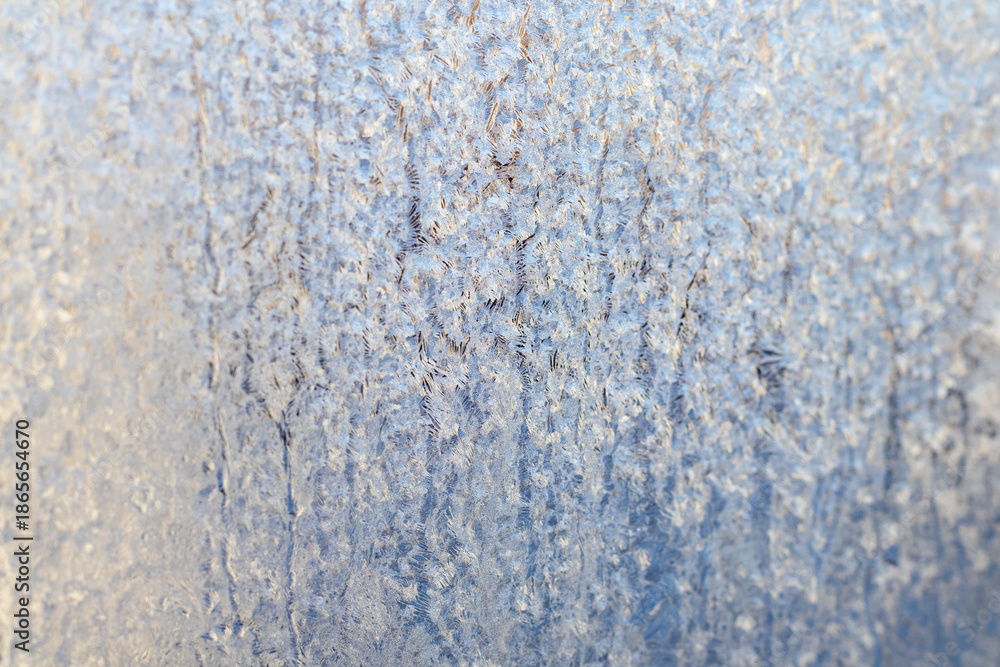 Fototapeta premium Frosted blue glass with intricate ice patterns creating a cool winter texture