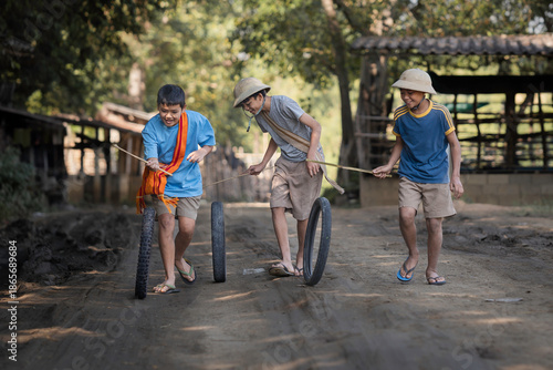 Happy Asian Boys Playing with Traditional Tire Rolling Toys.