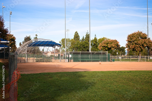 Photos Empty baseball field with dirt infield and backstop at a public sports park in Corona, California under clear skies