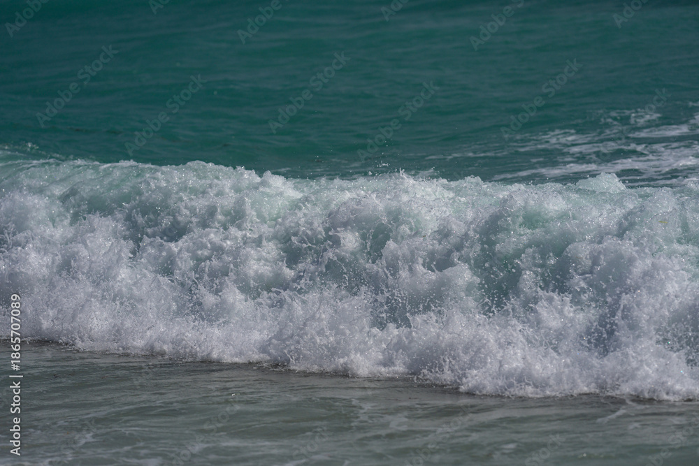 Fototapeta premium Sea beach background. Blue sea beach waves. Sandy sea beach shore. Sea beach ocean view. Summer sea beach scene.