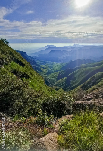 Dramatic mountain landscape of the Drakensberg Mountains with steep cliffs and rolling green valleys in South Africa