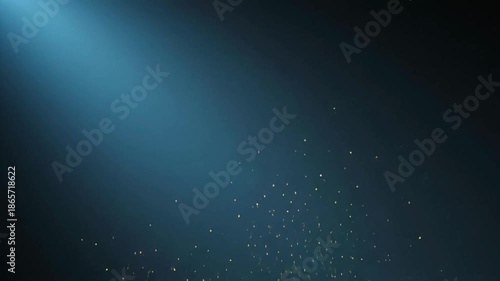 Vibrant golden particles swirling in dark space with blue spotlight