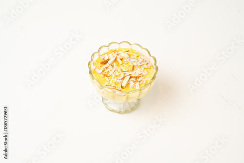 Fotografi Delicious dessert served in a clear glass cup, topped with a golden caramel drizzle and cream swirls