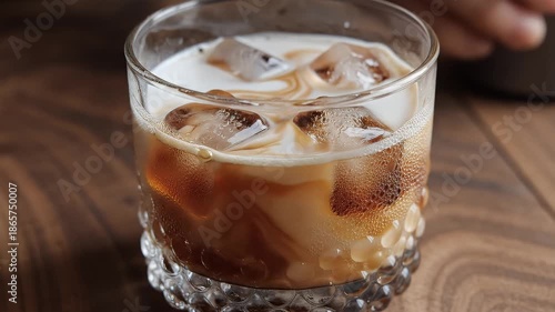 Glass of iced coffee on a wooden table.
