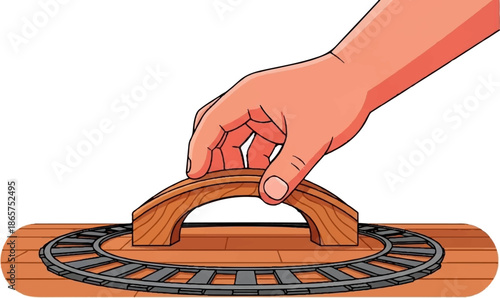 Hand holding a wooden train bridge over tracks