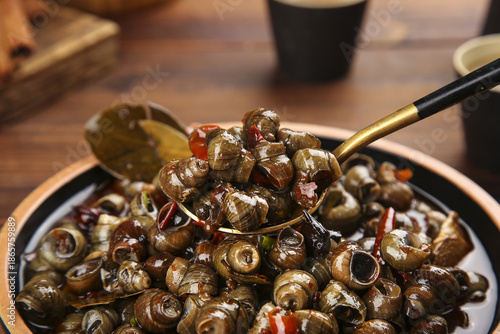Bild auf Leinwand Stir-Fried Snails with Spicy Peppers and Chopsticks