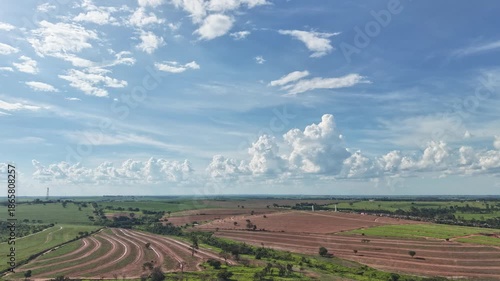 A timelapse video of a vast agricultural landscape under a blue sky with white clouds