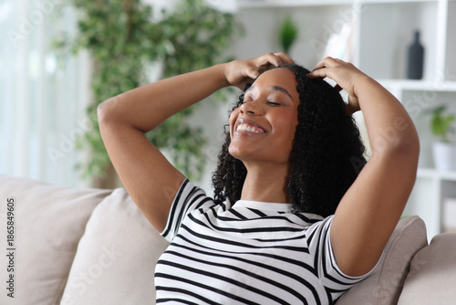 Happy black woman self massaging head with her hands