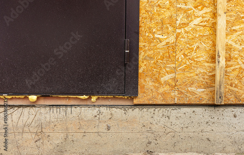 Plywood sheets on a concrete foundation, installation of OSB wall panels. Waterproofing of the house foundation. Close-up of the house foundation with waterproofing.