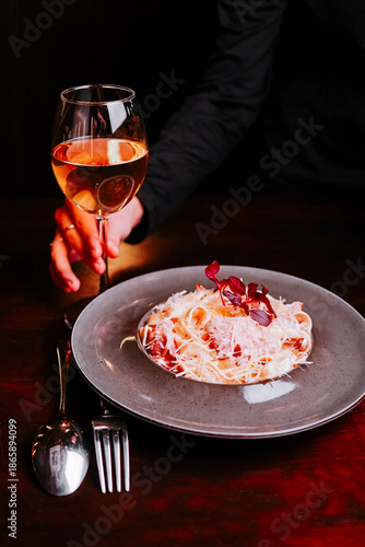 Enjoying a meal with a glass of wine at a dining table in a restaurant during the evening