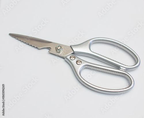 Stainless steel scissors are placed on a white surface.