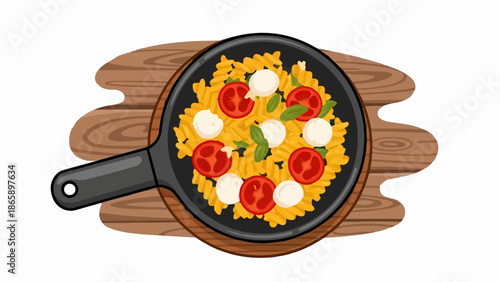Delicious pasta dish with cherry tomatoes and mozzarella balls in a black pan on a wooden surface