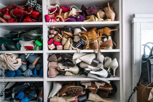 Cluttered closet shelves showing messy disorganized footwear collection