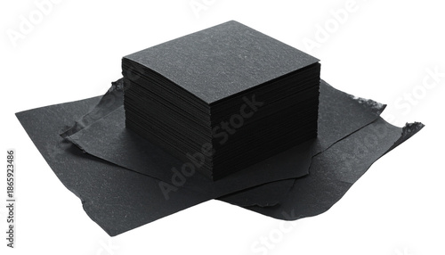 Square black paper napkins stacked neatly, with some loose at base
