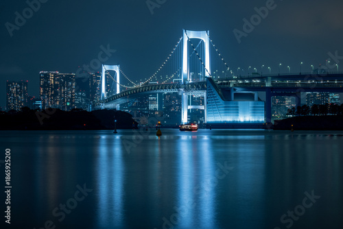 Blue and White Illuminated Rainbow Bridge at Night