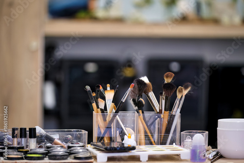 Makeup brushes and cosmetics arranged on a table in a beauty studio for application preparation