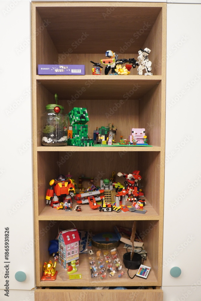 Obraz premium Collection of building block toys and figurines displayed on wooden shelves