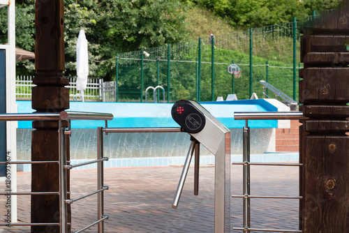 Canvas Print Entrance turnstile gate at swimming pool area on a sunny day.
