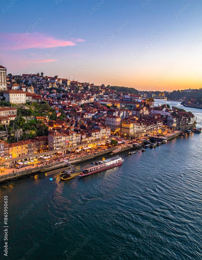 Fototapeta premium Aerial view of Porto, Portugal, showcasing the Douro River and cityscape at sunset.