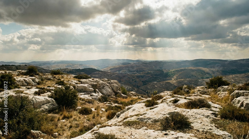 Dramatic clouds and sun rays over rocky mountains