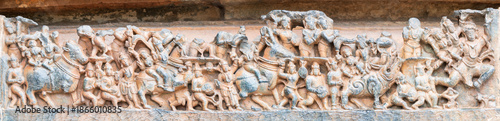 Detailed stone carving Halebeedu ancient temple Karnataka India showing warriors deities animals intricate sculptural art symbolizing heritage culture devotion