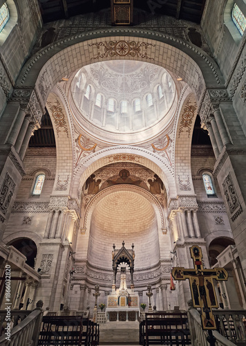 Interior altar view of the Basilique Saint-Martin de Tours. Byzantine-Romanesque architecture features intricate mosaics and golden patterns. Soaring dome and massive stone arches
