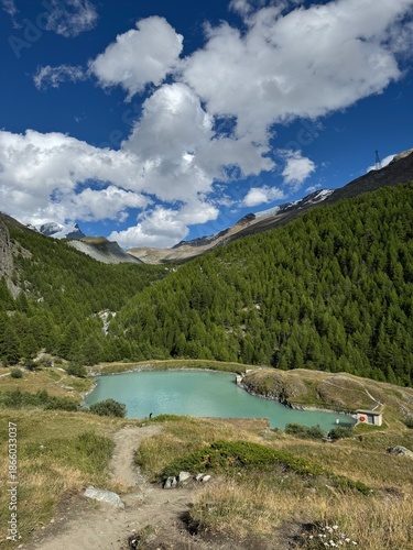 View of Mosjesee Lake (Moosjisee) under cloudy sky at summer. Mountain hiking trail of the Five Lakes Walk in Zermatt, Switzerland.