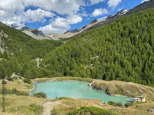 View of Mosjesee Lake (Moosjisee) under cloudy sky at summer. Mountain hiking trail of the Five Lakes Walk in Zermatt, Switzerland.