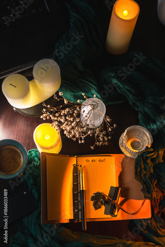 Cozy workspace with to-do list, coffee and candles – planning and mindfulness concept