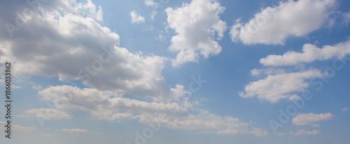 Panoramic blue sky with white floating clouds