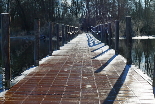 Pontile innevato in Gennaio con silhouette di passanti