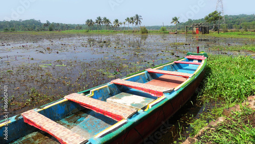 A colorful wooden boat parked aside a flooded farmland in Kerala, India