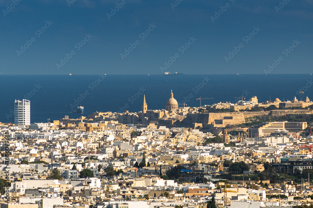 Fototapeta premium Malta from Above. High-angle panoramic view from the ancient bastions of Valletta looking over the dense urban landscape of Malta towards the distant Mediterranean Sea horizon. Valletta landscape.