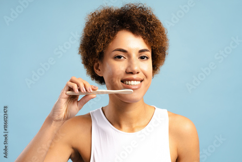 Obraz na plátne Smiling beautiful African American woman holding toothbrush promoting oral care