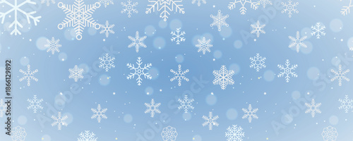 A beautifully soft and delicate winter background featuring snowflakes and a gentle bokeh effect. The white snowflakes are scattered across a subtle grey backdrop, creating a serene and festive atmosp