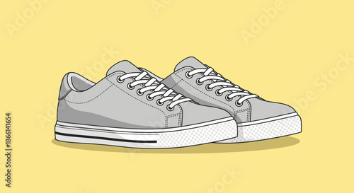 A pair of gray canvas sneakers with white laces on a yellow background.