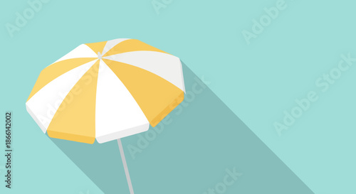 Yellow and white beach umbrella casting a long shadow.