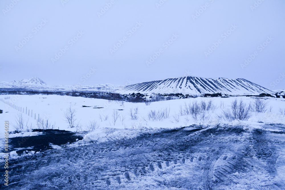 Obraz premium Frosted volcanic landscape with pathways to crater formations
